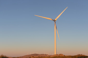 Obraz premium Windmills on a hillside at sunset