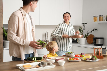 Happy little boy with his parents cooking Fajita in kitchen