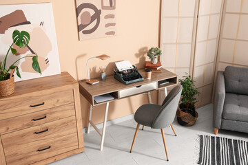 Stylish workspace with vintage typewriter, cup of coffee and books in living room