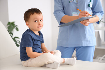 Cute little boy on couch visiting pediatrician in clinic