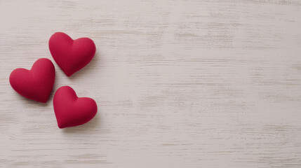 Obraz premium Three red heart-shaped decorations on wooden surface with copyspace, symbolizing love and affection.