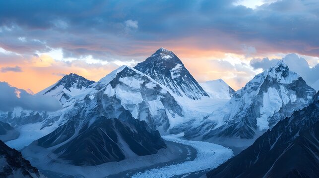 The majestic view of snow-capped mountains against a cloudy sky during sunset