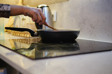 Cooking in the Kitchen Stirring Delicious Food in a Pan on the Stove