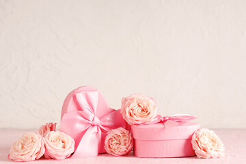 Roses with gift boxes on table against white background. Valentine's Day celebration
