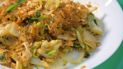 stir fried sukiyaki with egg and pork on white plate