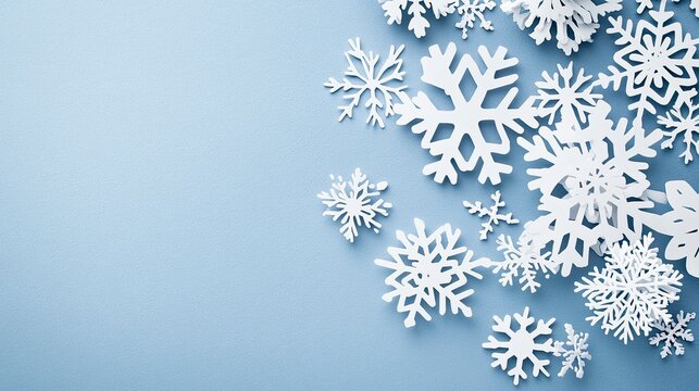 An assortment of intricately designed white snowflakes scattered across a soft blue background evoking a winter wonderland feel.