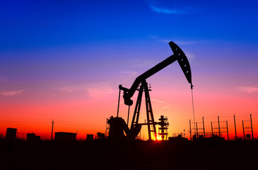 The pumping unit is working, in the silhouette of sunset