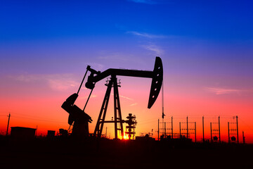 The pumping unit is working, in the silhouette of sunset
