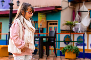 Beautiful Latin girl with scarf and jacket enjoying her vacation in Colombia. Trips and excursions, people smiling. Children's day. 