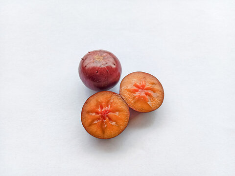 Rukam, ramontchi, governor's plum, Indian plum, and Indian prune. Fruits slices on white background. Flacourtia fruits. 