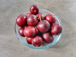 Flacourtia fruit in a bowl. Rukam, ramontchi, governor's plum, Indian plum, and Indian prune. Bowl of fruits.