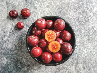 Flacourtia fruit in a bowl. Rukam, ramontchi, governor's plum, Indian plum, and Indian prune. Bowl of fruits.
