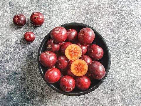 Flacourtia fruit in a bowl. Rukam, ramontchi, governor's plum, Indian plum, and Indian prune. Bowl of fruits.