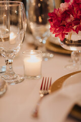 Elegant Table Setting with Candlelight and Pink Floral Arrangement, Highlighting Sophisticated Event Decor and Luxurious Details