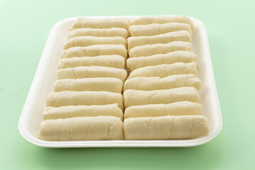 Detalle de deditos de queso y empanadas congeladas sobre una superficie texturizada, representando aperitivos tradicionales listos para preparar y disfrutar.