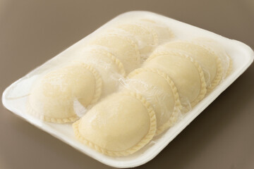Detalle de deditos de queso y empanadas congeladas sobre una superficie texturizada, representando aperitivos tradicionales listos para preparar y disfrutar.