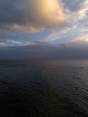 Fototapeta premium Dramatic Sunset Over the Ocean with Clouds and Calm Water