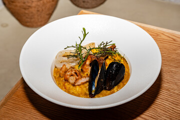 gourmet preparation of seafood risotto, made with shrimps, mussels, squid, seaweed and vegetables