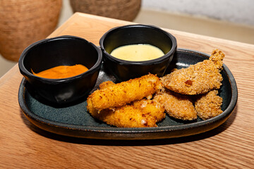 breaded chicken fingers and cheese fingers with cilantro mayonnaise sauce and paprika sauce
