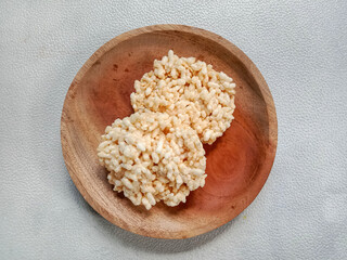 Rengginang or rice cracker, traditional snacks made from glutinous rice, savory and crunchy. Served on wooden plate. Top view. Indonesian food.