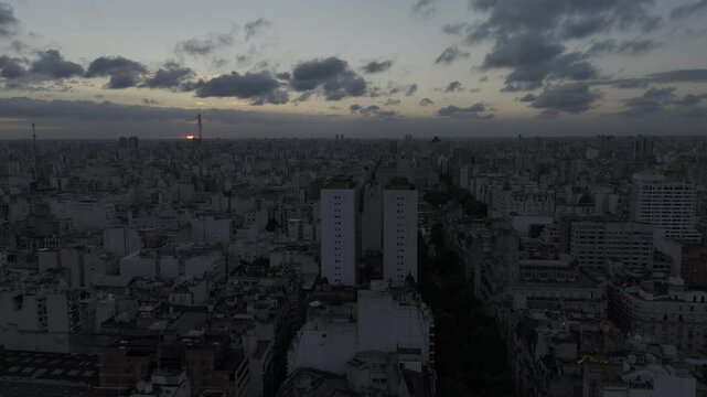 Drone flies down Avenida de Mayo after sunset, past Palacio Barolo, over Plaza Mariano Moreno and the National Congress in Buenos Aires, Argentina