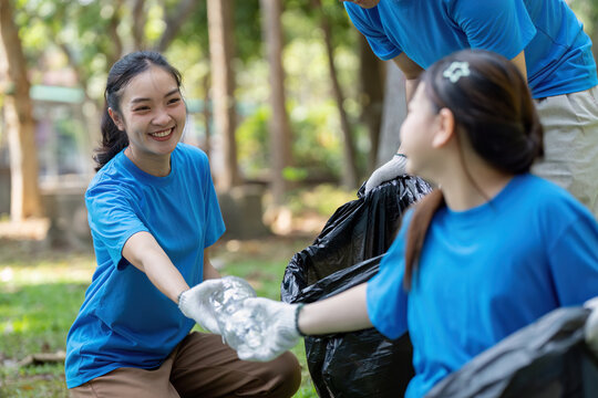 Family volunteers collecting garbage in community park nature cleanup event outdoor family activity engaging community efforts