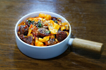 식탁 위에 놓인 떡볶이, 순대, 튀김 만두의 모습