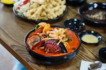 식탁 위에 얼큰한 해물짬뽕과 탕수육이 놓여 있는 모습