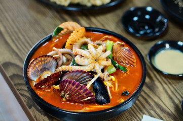 식탁 위에 얼큰한 해물짬뽕과 탕수육이 놓여 있는 모습