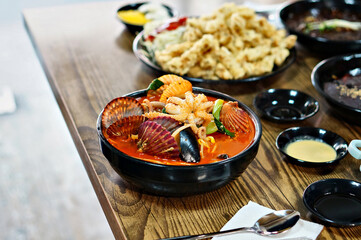 식탁 위에 얼큰한 해물짬뽕과 탕수육이 놓여 있는 모습