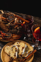 Mulled wine with cinnamon sticks and stollen on a wooden table