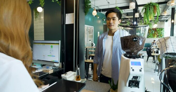 Customer using e-payment with mobile to buy hot drink in coffeeshop