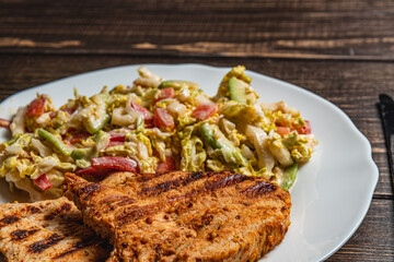 Delicious Grilled turkey Served with a salad on a Rustic Wooden Dining Table