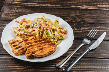 Delicious Grilled turkey Served with a salad on a Rustic Wooden Dining Table