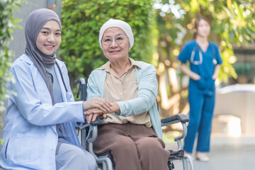 Obraz premium a young female health care worker in hijab take care senior cancer patient in wheelchair,talking,empowering,empathy,mental care