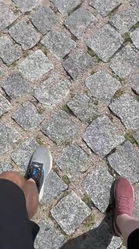 nogi dw&oacute;ch os&oacute;b spacerujących razem