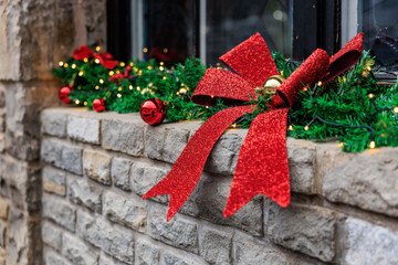 Festive red bow and ornaments on christmas decorated brick ledge