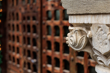 Ornate stone carving with historic wooden gate in background