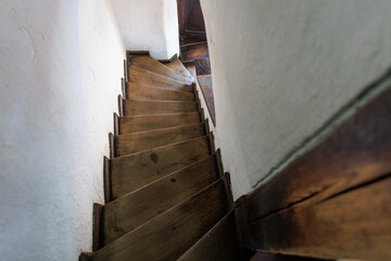Narrow wooden staircase in old european building interior