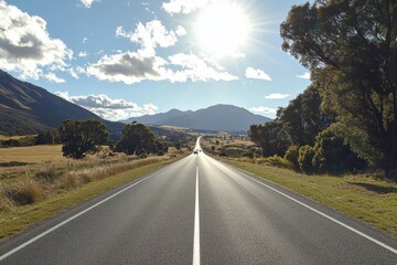 Naklejka premium Sunny road stretching towards distant mountains.