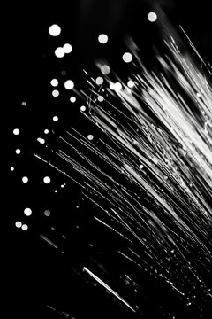 Close-up of numerous parallel optical fibers with blurred lines, creating an abstract, high-tech image. Keywords include communication infrastructure, data transfer, and digital connectivity.