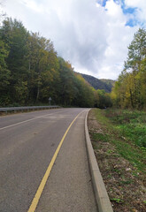 Fototapeta premium paved highway in a mountainous area in early autumn with panoramic views