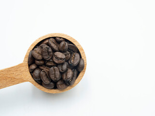 coffee beans in wooden spoon isolated on white background