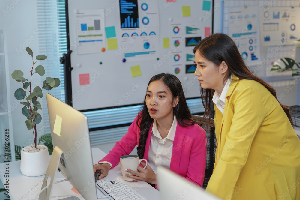 Poster two asian businesswomen collaborating on a computer in a modern office, analyzing data and discussin
