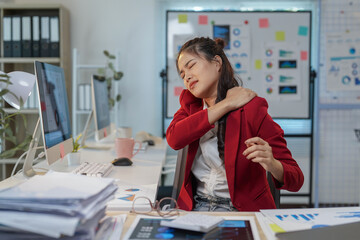 Young professional woman massaging her neck, experiencing discomfort and stiffness after prolonged...