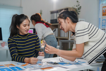 Two female ux designers collaborating on a mobile app interface, analyzing wireframes and discussing user experience strategies in a modern office