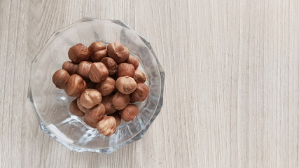 Amino acids in hazelnuts. Hazelnuts in a glass cup on a white background. Fats, proteins, and...