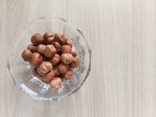 Amino acids in hazelnuts. Hazelnuts in a glass cup on a white background. Fats, proteins, and dietary fiber in nuts. 