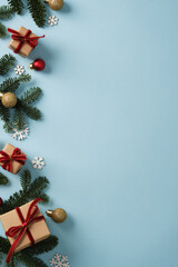 Christmas gifts made of brown kraft paper with red velvet ribbons and sprigs of evergreen fir tree on blue background. Space for your text.