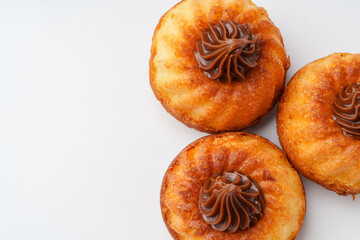 Delicious pastries topped with chocolate cream arranged on a white surface in a tempting display